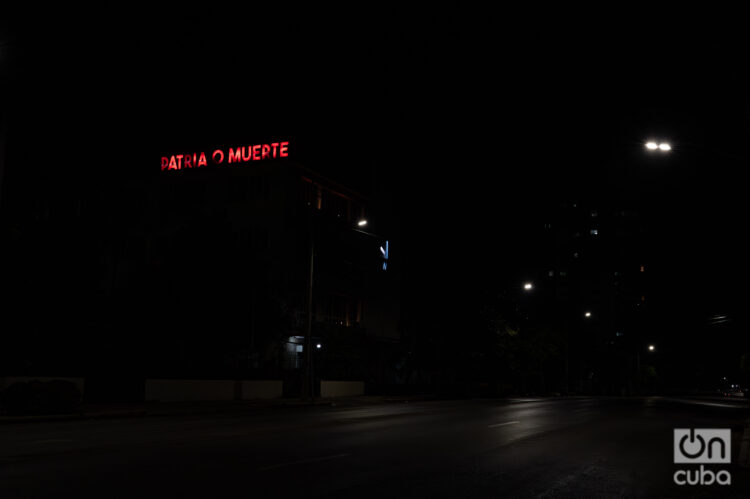 Un cartel lumínico con la frase "Patria o Muerte" se observa en una calle a oscuras en La Habana. Foto: Kaloian.