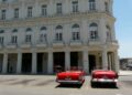 Dos solitarios descapotables en espera de algún turista frente al Gran Hotel Manzana Kempinski, en La Habana, en mayo de 2026. Foto: AMD.