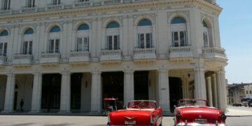 Dos solitarios descapotables en espera de algún turista frente al Gran Hotel Manzana Kempinski, en La Habana, en mayo de 2026. Foto: AMD.