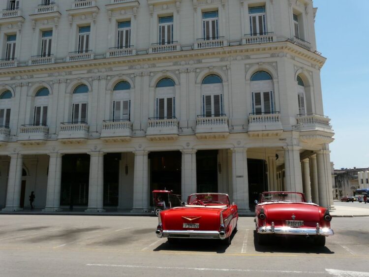 Dos solitarios descapotables en espera de algún turista frente al Gran Hotel Manzana Kempinski, en La Habana, en mayo de 2026. Foto: AMD.