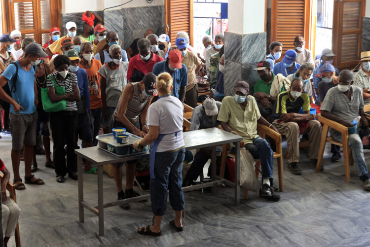 Personas reciben alimentos por personal de la ONG Quisicuaba este lunes, en La Habana (Cuba). Foto: EFE/ Ernesto Mastrascusa.