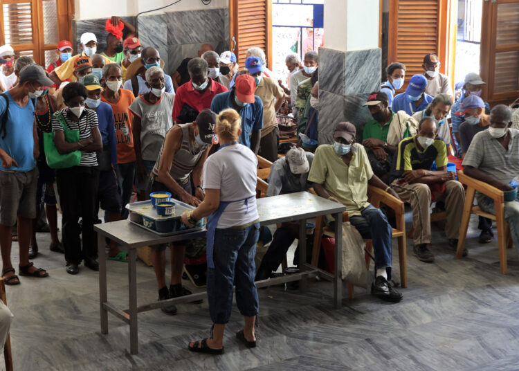 Personas reciben alimentos por personal de la ONG Quisicuaba este lunes, en La Habana (Cuba). Foto: EFE/ Ernesto Mastrascusa.