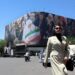 Una mujer camina junto a una enorme valla publicitaria en una calle de Teherán, Irán. Foto:  Abedin Taherkenareh/EFE.