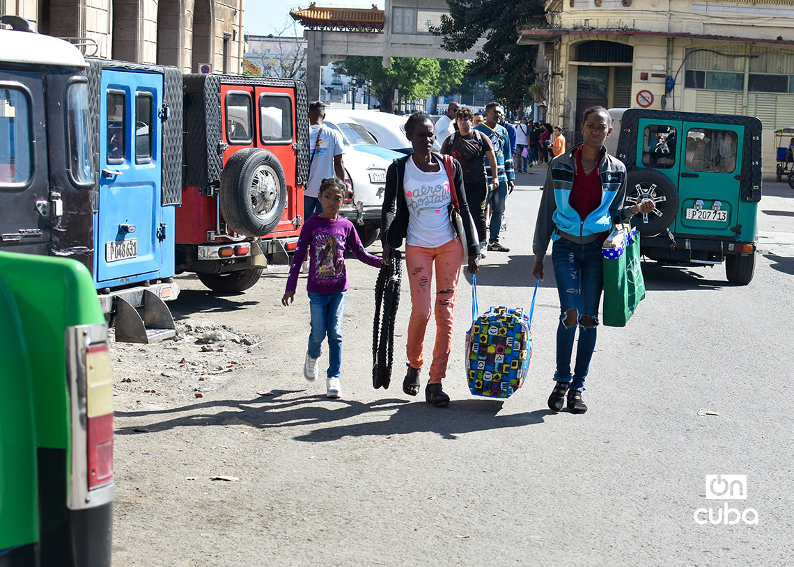 Dos mujeres con una niña y posesiones personales, en La Habana. Foto: Otmaro Rodríguez.