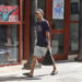 Un joven con una camiseta de EE.UU camina junto a un cartel alegórico a la Revolución Cubana, en La Habana. Foto: Ernesto Mastrascusa / EFE.