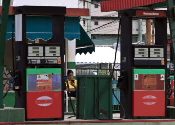 Una persona observa un celular mientras espera clientes en una gasolinera este viernes, en La Habana (Cuba). Foto:  Ernesto Mastrascusa/EFE.