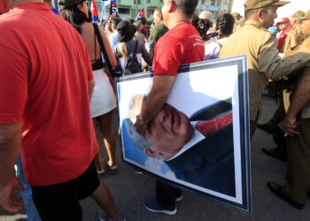 Una persona sostiene una imagen del presidente de Cuba, Miguel Diaz- Canel, durante la conmemoración del Día Internacional del Trabajo, en La Habana. Foto: Ernesto Mastrascusa /EFE.