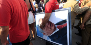 Una persona sostiene una imagen del presidente de Cuba, Miguel Diaz- Canel, durante la conmemoración del Día Internacional del Trabajo, en La Habana. Foto: Ernesto Mastrascusa /EFE.