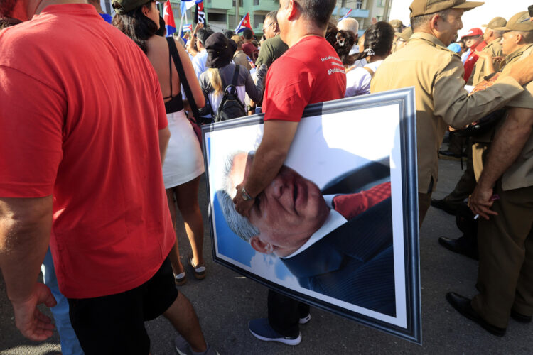 Una persona sostiene una imagen del presidente de Cuba, Miguel Diaz- Canel, durante la conmemoración del Día Internacional del Trabajo, en La Habana. Foto: Ernesto Mastrascusa /EFE.