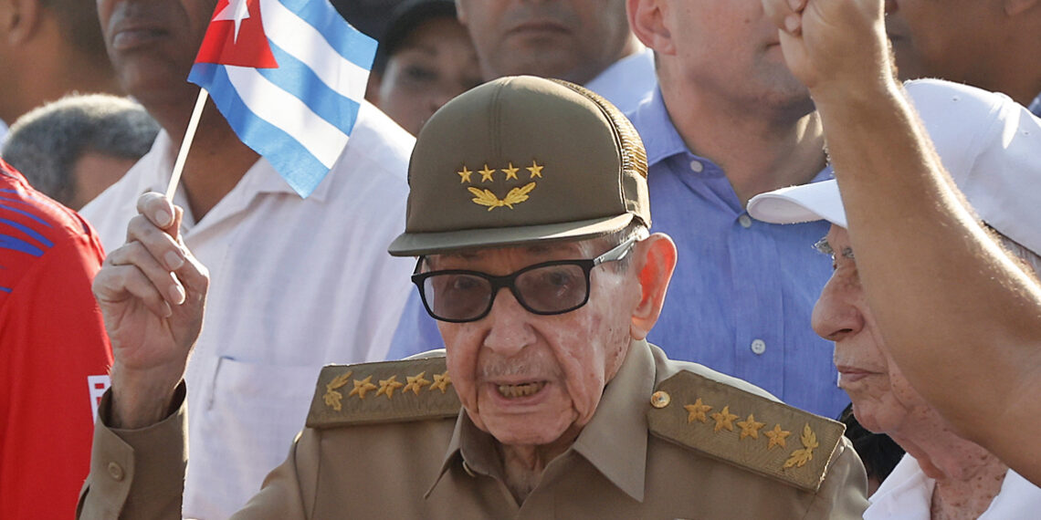 Raúl Castro sosteniendo una bandera de Cuba durante la conmemoración del Día Internacional del Trabajo en La Habana. Foto:  Ernesto Mastrascusa/EFE.