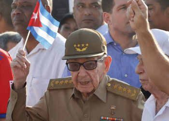 Raúl Castro sosteniendo una bandera de Cuba durante la conmemoración del Día Internacional del Trabajo en La Habana. Foto:  Ernesto Mastrascusa/EFE.