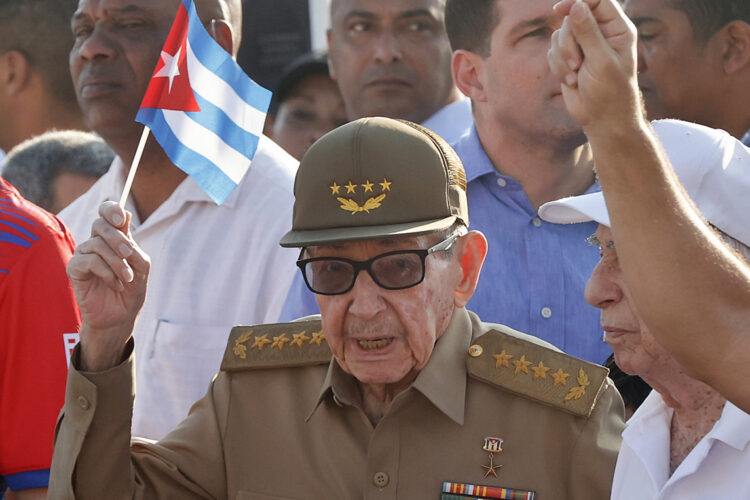 Raúl Castro sosteniendo una bandera de Cuba durante la conmemoración del Día Internacional del Trabajo en La Habana. Foto:  Ernesto Mastrascusa/EFE.
