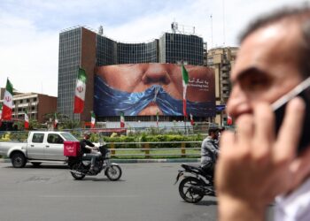 Personas cerca de una enorme valla publicitaria antiestadounidense con una foto del presidente estadounidense Donald Trump en la plaza Valiasr de Teherán. Foto: ABEDIN TAHERKENAREH/EFE/EPA.