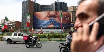 Personas cerca de una enorme valla publicitaria antiestadounidense con una foto del presidente estadounidense Donald Trump en la plaza Valiasr de Teherán. Foto: ABEDIN TAHERKENAREH/EFE/EPA.
