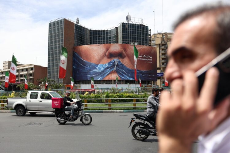 Personas cerca de una enorme valla publicitaria antiestadounidense con una foto del presidente estadounidense Donald Trump en la plaza Valiasr de Teherán. Foto: ABEDIN TAHERKENAREH/EFE/EPA.