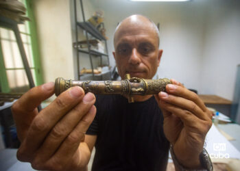 El artista y restaurador Pavel Valdés Ruiz, gestor no estatal del Museo de la Pintura Mural, de La Habana Vieja, con un cañón de su autoría. Foto: Otmaro Rodríguez.