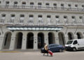 Una mujer camina frente a un hotel , en La Habana. Foto: Ernesto Mastrascusa/EFE.