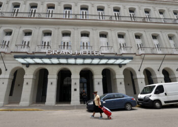 Una mujer camina frente a un hotel , en La Habana. Foto: Ernesto Mastrascusa/EFE.
