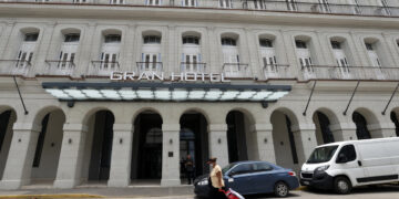 Una mujer camina frente a un hotel , en La Habana. Foto: Ernesto Mastrascusa/EFE.