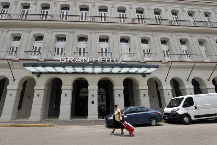 Una mujer camina frente a un hotel , en La Habana. Foto: Ernesto Mastrascusa/EFE.