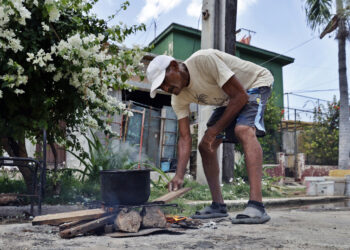 Una persona cocinando en la calle en La Habana. Foto: Ernesto Mastrascusa/EFE.