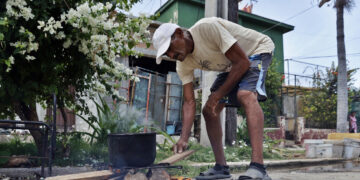 Una persona cocinando en la calle en La Habana. Foto: Ernesto Mastrascusa/EFE.