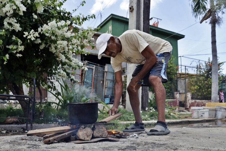 Una persona cocinando en la calle en La Habana. Foto: Ernesto Mastrascusa/EFE.