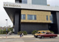 Personas transitan frente a un hotel, en La Habana. Foto: Ernesto Mastrascusa/EFE.