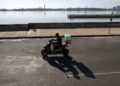 Una persona en motocicleta por el malecón. Foto: Ernesto Mastrascusa/EFE.