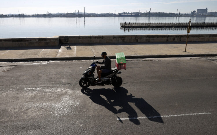 Una persona en motocicleta por el malecón. Foto: Ernesto Mastrascusa/EFE.