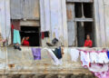 Personas saludan desde un balcón, en La Habana. Foto:  Ernesto Mastrascusa/EFE.