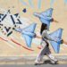 Una joven iraní pasa junto a un mural antiisraelí en una calle de Teherán, Irán. Foto: ABEDIN TAHERKENAREH / EFE/ EPA.