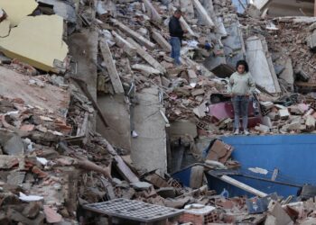 Residentes caminan entre los escombros de edificios derrumbados por los terremotos, en la localidad de Catia La Mar, en el estado costero de La Guaira. Foto: Ronald Pena R./ EFE.