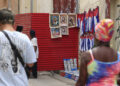 Personas caminando junto a un lugar de venta de artesanías en La Habana. Foto: Ernesto Mastrascusa/ EFE.