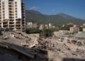 Personas observan los escombros de un edificio este lunes, en La Guaira. Foto:  Ronald Peña R/EFE.