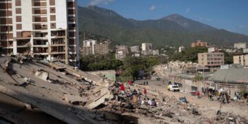 Personas observan los escombros de un edificio este lunes, en La Guaira. Foto:  Ronald Peña R/EFE.