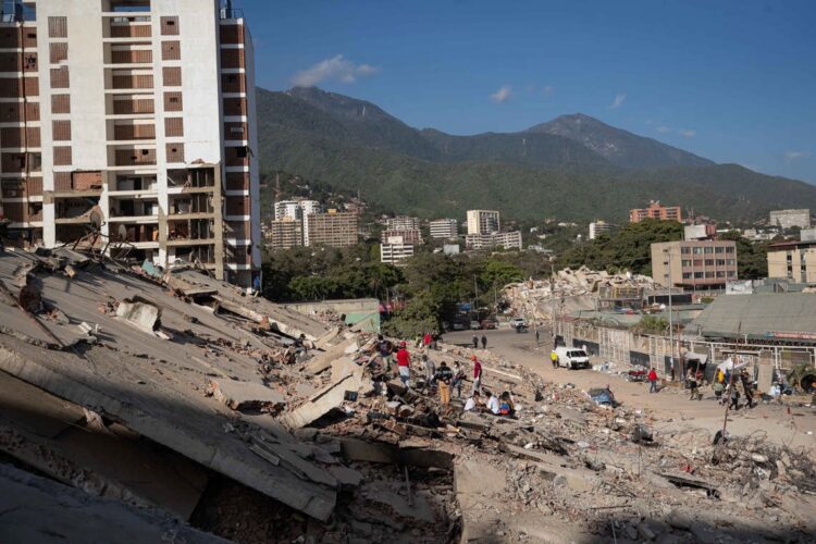 Personas observan los escombros de un edificio este lunes, en La Guaira. Foto:  Ronald Peña R/EFE.