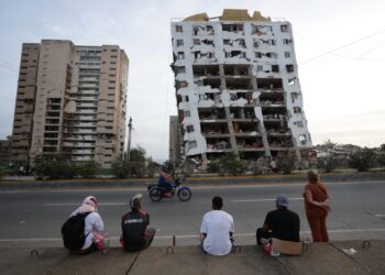 Residentes observan uno de los bloques de viviendas dañados por los terremotos, en la localidad de Catia La Mar, en el estado costero de La Guaira. Foto: Ronald Pena R./ EFE.