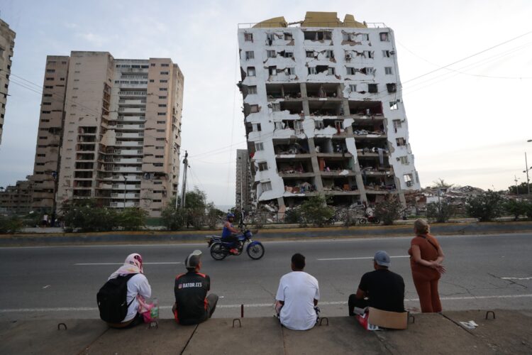 Residentes observan uno de los bloques de viviendas dañados por los terremotos, en la localidad de Catia La Mar, en el estado costero de La Guaira. Foto: Ronald Pena R./ EFE.
