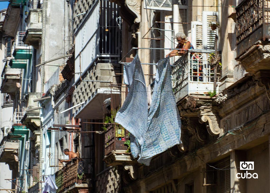 Una mujer tiende ropa en un balcón en La Habana, tras lavar a la llegada de la electricidad. Foto: Otmaro Rodríguez.
