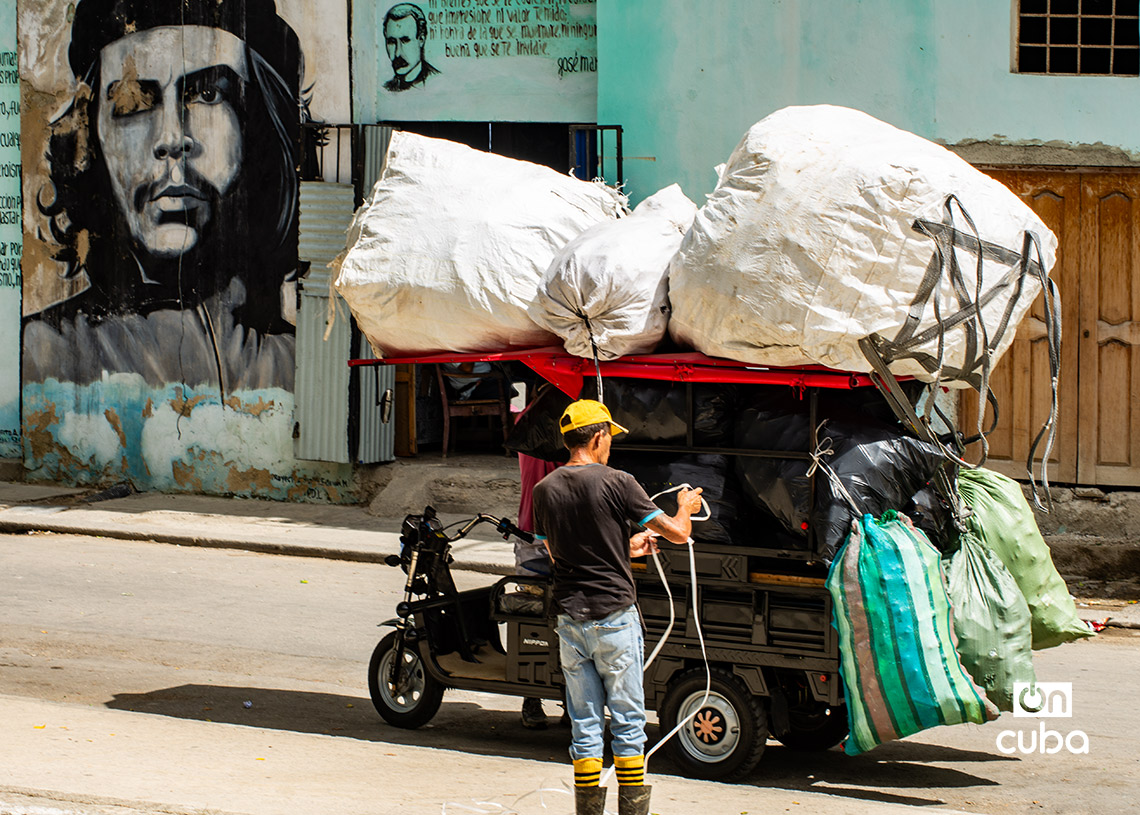 Un hombre transporta pomos plásticos vacíos en La Habana. Foto: Otmaro Rodríguez.