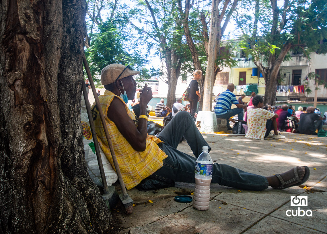 Personas reciben comida en la Plaza de Cataluña en Ayestarán, La Habana. Foto: Otmaro Rodríguez.