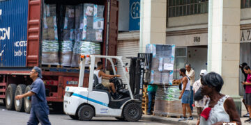 Trabajadores descargando mercancía en una tienda en la calle Galiano, en La Habana. Foto: Otmaro Rodríguez.