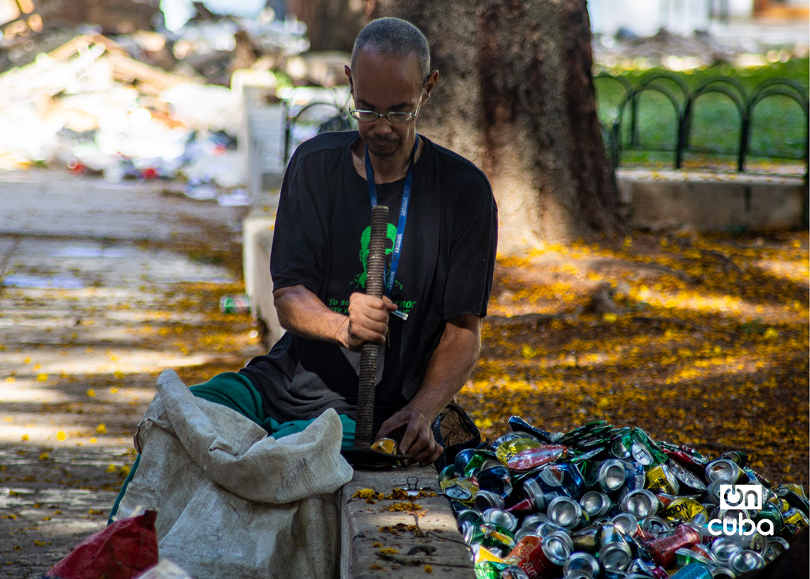 Un hombre aplasta latas vacías para venderlas como materia prima en La Habana. Foto: Otmaro Rodríguez.