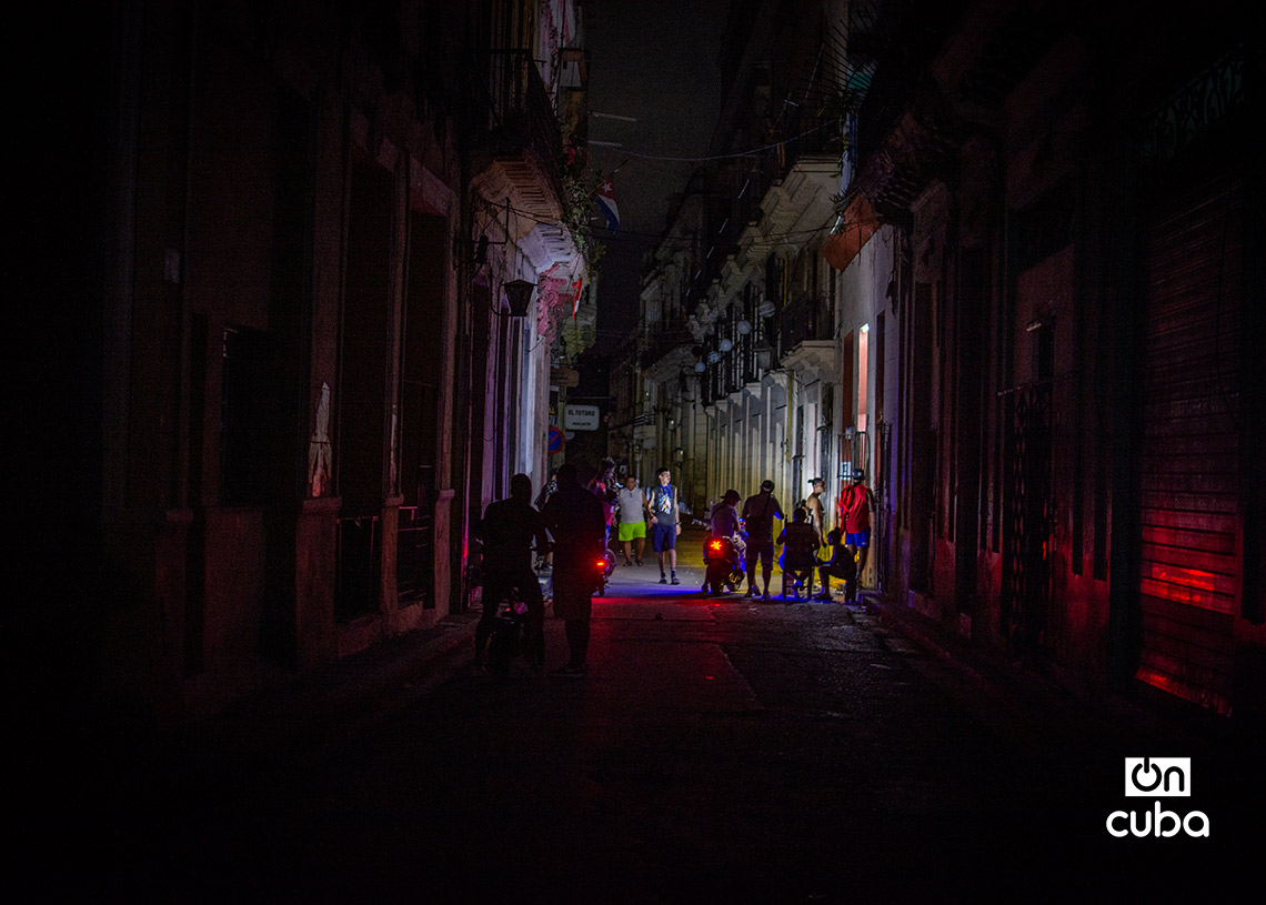 Personas en las afuera de una mypime en la calle Cuarteles, durante un apagón. Foto: Otmaro Rodríguez.
