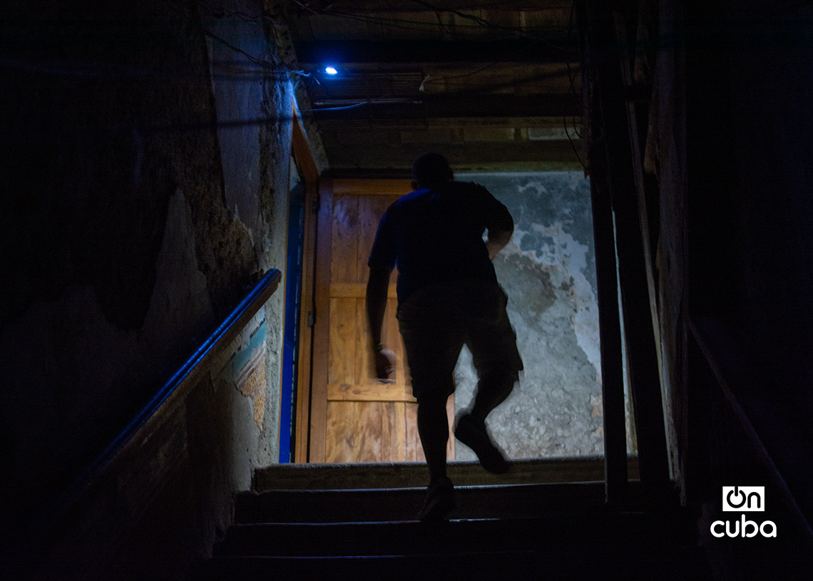 Un hombre sube una escalera hacia su hogar durante un apagón en la Habana Vieja. Foto: Otmaro Rodríguez.
