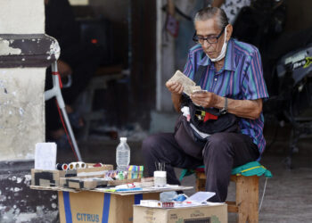 Un anciano cuenta dinero resultado de su puesto de venta particular en La Habana. Foto: Ernesto Mastrascusa / EFE / Archivo.