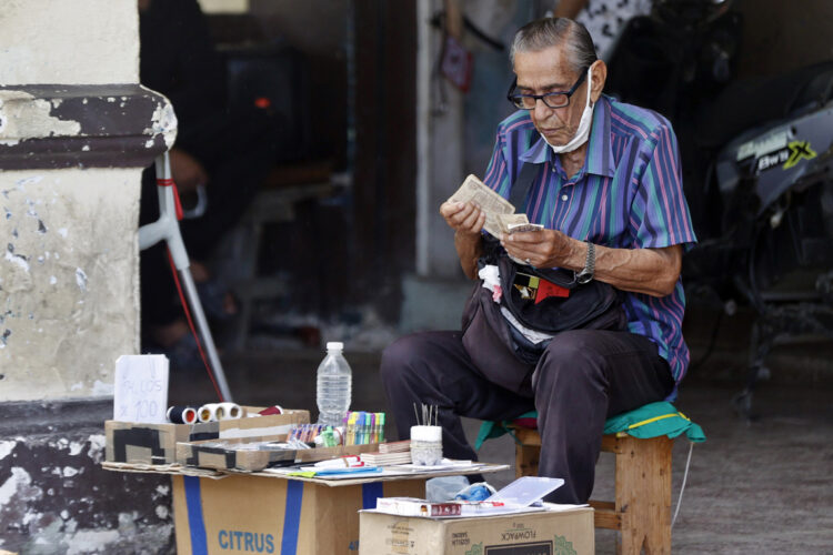 Un anciano cuenta dinero resultado de su puesto de venta particular en La Habana. Foto: Ernesto Mastrascusa / EFE / Archivo.