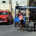 Un hombre vestido con una camiseta de la bandera de EE.UU., empuja un bicitaxi en La Habana. Foto: Ernesto Mastrascusa / EFE.