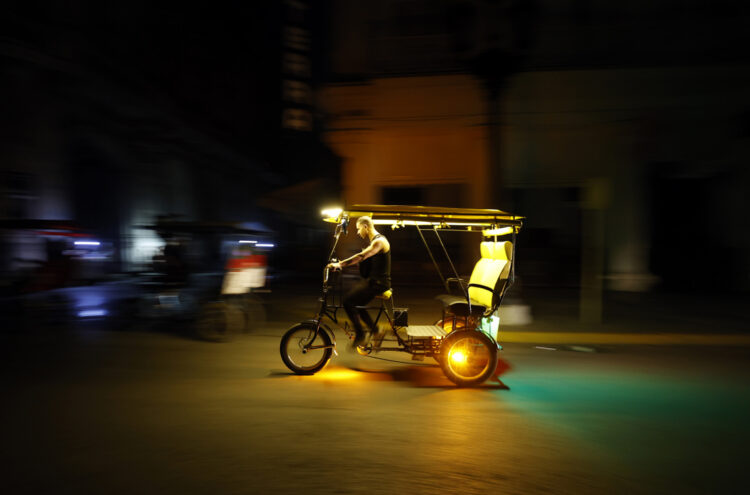 Un hombre conduce un bicitaxi durante un apagón este martes, en La Habana. Foto: Ernesto Mastrascusa/EFE.